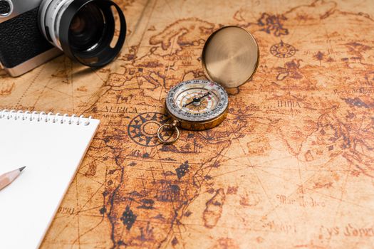 Vintage Compass and camera on map for travel planning