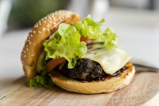 Hamburger on the wooden plate. Fast food concept