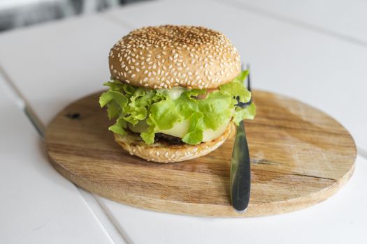 Hamburger on the wooden plate. Fast food concept