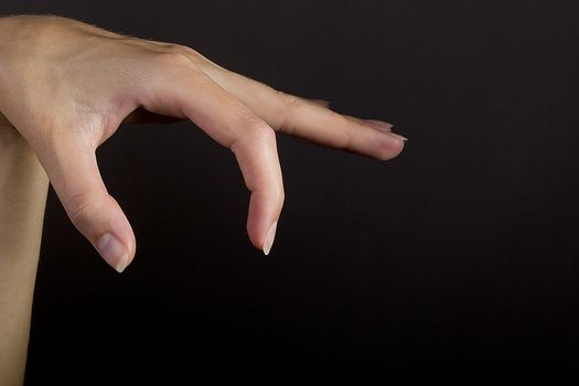 Female hand grab some item on black isolated background