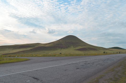 summer landscape with road, mountain and blue sky with clouds