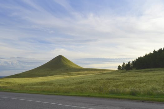 summer landscape with road, mountain and blue sky with clouds