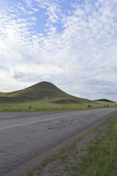 summer landscape with road, mountain and blue sky with clouds