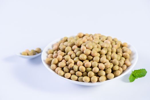 Yellow-green Taiwanese organic non-GMO soybeans, soy beans in a container isolated on white backgorund, close up, clipping path.