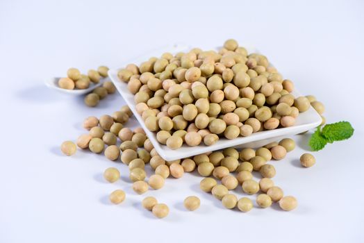 Yellow-green Taiwanese organic non-GMO soybeans, soy beans in a container isolated on white backgorund, close up, clipping path.