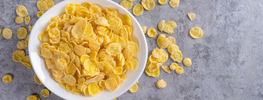 Corn flakes bowl sweets on gray cement background, top view flat lay layout design, fresh and healthy breakfast concept.