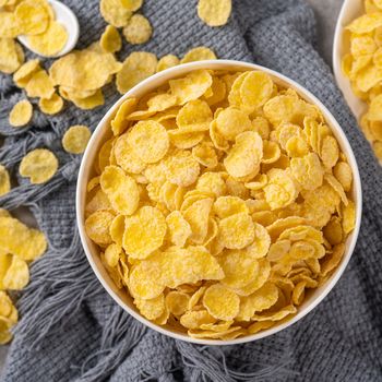 Corn flakes bowl sweets on gray cement background, top view flat lay layout design, fresh and healthy breakfast concept.