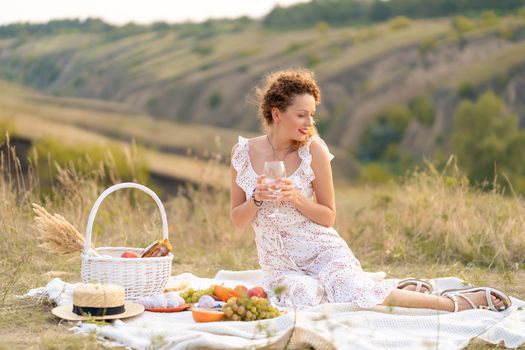 Beautiful girl on a picnic in a picturesque place. Romantic picnic.