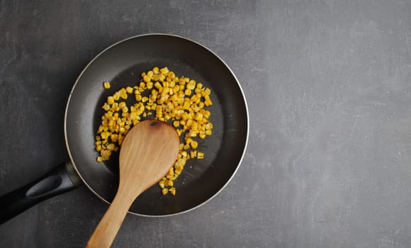 Diet. Organic Grilled Corn in a frying pan. Organic farm vegetables. Gray background Top view. Wooden spoon. Vegetarian food. Environmentally friendly products