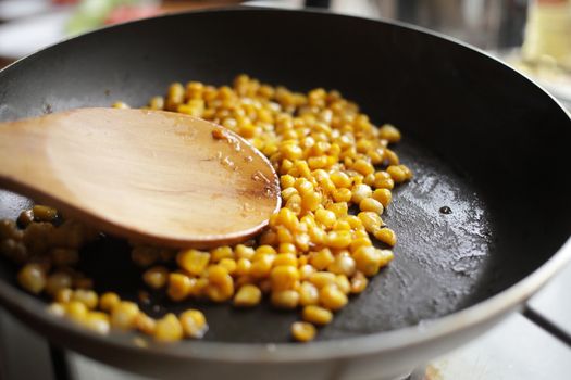 Diet. Organic Grilled Corn in a frying pan. Organic farm vegetables. Gray background Top view. Wooden spoon. Vegetarian food. Environmentally friendly products