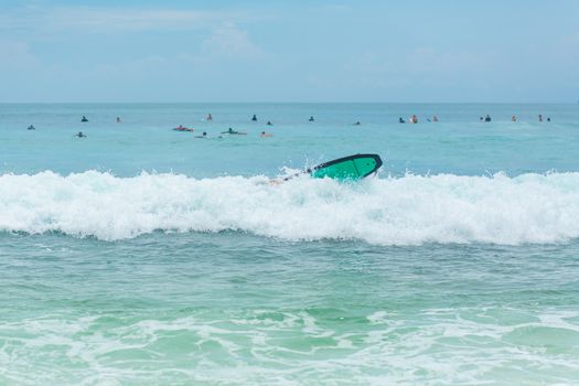 The guy is swimming on the surf board on the ocean. Healthy active lifestyle in summer vocation