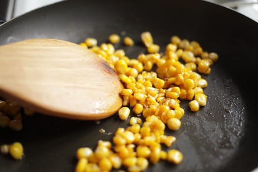 Diet. Organic Grilled Corn in a frying pan. Organic farm vegetables. Gray background Top view. Wooden spoon. Vegetarian food. Environmentally friendly products