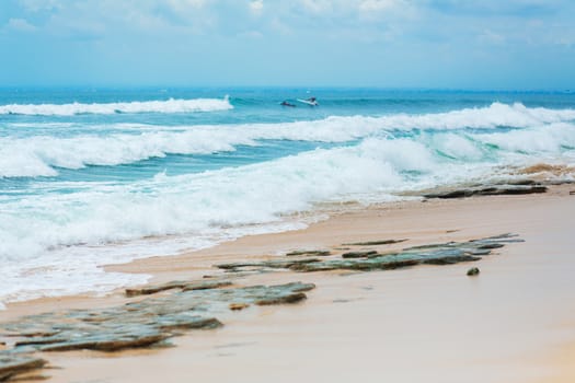 An ideal tropical sandy beach for surfing on the ocean. Beautiful clear turquoise water and waves