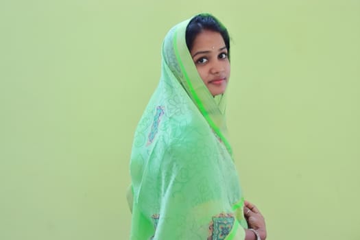 A indoors portrait of young lady model in new lunch green saree design on empty background