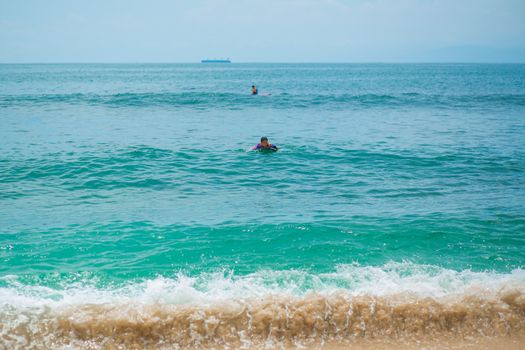 Sexy slim girl riding on surf board in the ocean. Healthy active lifestyle in summer vocation