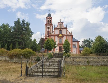 Pink and white baroque church of saint Mary Magdalene in Marenice, Czech Republic, sunny summer day, vibrant colors