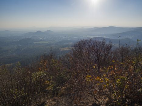 Lusatian Mountains or luzicke hory, view from Klic or Kleis one of the most attractive view-points of the Lusatian Mountains with autumn colored deciduous and coniferous tree forest and green hills, golden hour light.