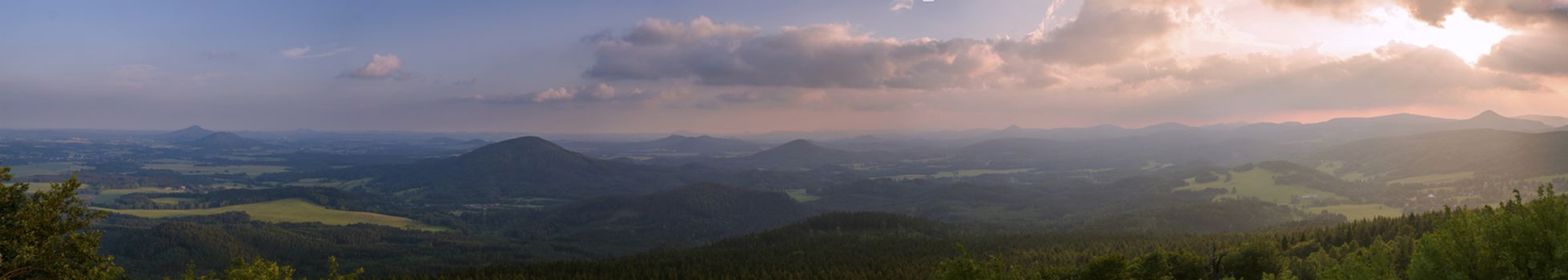 Lusatian Mountains (luzicke hory) wide panorama, panoramic view from Hochwald (Hvozd) mountain on czech german borders with blue green hills forest and pink cloudy sunset sky background