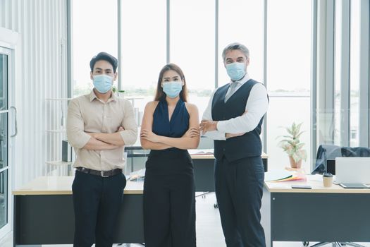 portrait Multi-ethnic male and female business group Everyone is wearing a medical mask. Smile and look at the camera. social distancing is the new normal. Background for laptops and office desks