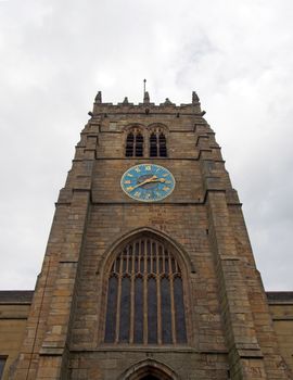 the tower of medieval bradford cathedral in west yorkshire with clock and windows