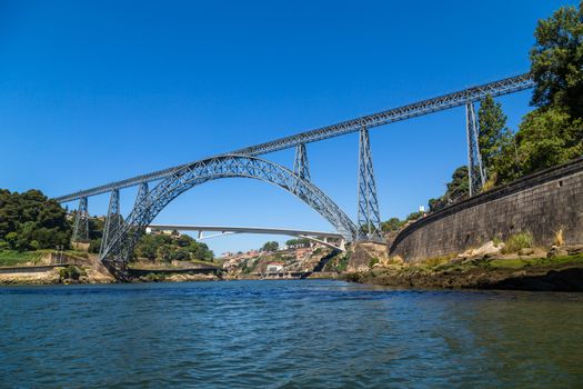 Maria Pia Bridge over the Douro river, Porto, Portugal. View from the water. Wrought iron railway bridge. One of the most popular touristic destinations.