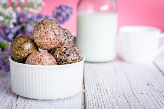 Healthy snack. Energy ball with date plam, black and white sesame, chia and rasin in ceramic bowl on wooden table. Vegan vegetarian.