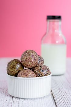 Healthy snack. Energy ball with date plam, black and white sesame, chia and rasin in ceramic bowl on wooden table. Vegan vegetarian.