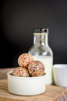 Healthy snack. Energy ball with date plam, black and white sesame, chia and rasin in ceramic bowl on wooden table. Vegan vegetarian.