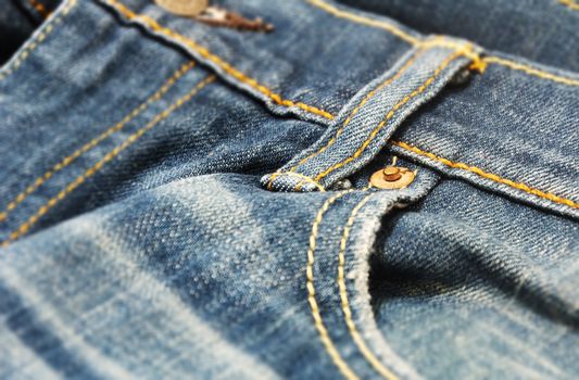 close-up view of the copper rivet on the pocket of a pair of denim trousers. Casual and workwear. Denim fabric for jeans trousers