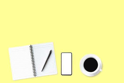 Flat lay composition with notebook, pen, hot coffee on yellow background.