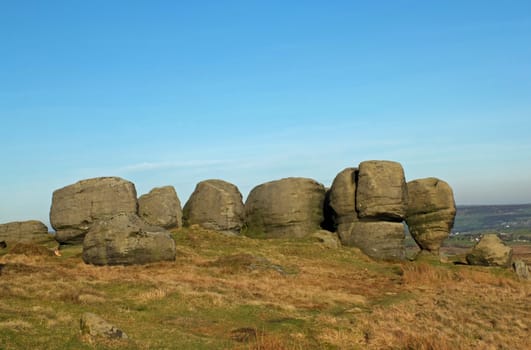 view of the top of the bridestones a large group of gritstone rock formations in west yorkshire landscape near todmorden