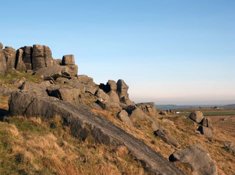 large rugged gritstone outcrop at the bridestones a large rock formation in west yorkshire near todmordenwith blue sky and surrounding countryside