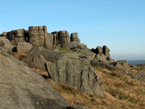 large rugged gritstone outcrop at the bridestones a large rock formation in west yorkshire near todmorden with blue sunlit sky