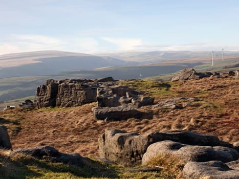 bridestones moor in west yorkshire with gritstone outcrops surrounded by hills on a sunny day