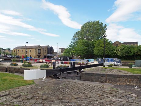 a view of the lock gates at the entrance to brighouse basin and moorings on the calder and hebble navigation canal in calderdale west yorkshire