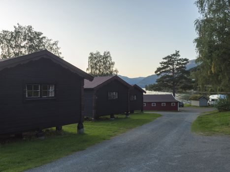 View of Classical Norwegian Camping site Bravoll with traditional wooden cottages cabins at Kinsarvik by the Sorfjorden branch of Hardanger Fjord in Kinsarvik, Norway........