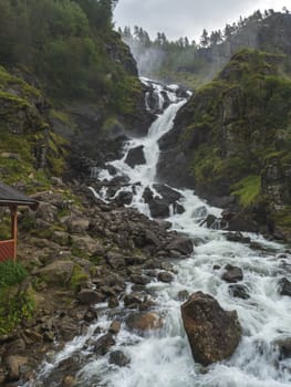 Powerful twin waterfall Latefoss or Latefossen and six arched bridge along Route 13, Odda Hordaland County in Norway. Early autumn, moody sky