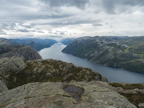 View on fjord Lysefjord, next to Preikestolen massive cliff famous Norway viewpoint Moody sky, autumn day. Nature and travel background, vacation and hiking holiday