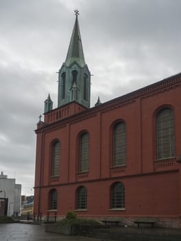 STAVANGER, NORWAY, SEPTEMBER 9, 2019 :View on St. Peter Church or St. Petri Kirke is red brick building and was built in 1866, Stavanger city center. Rainy moody day. Travel and architecture background.