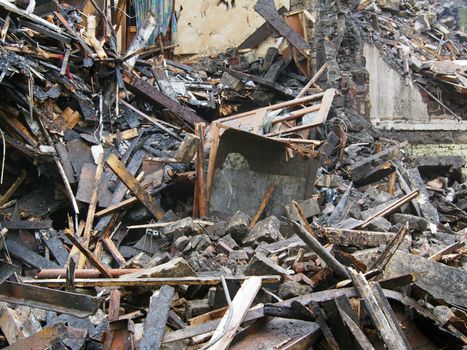 black burned timbers and walls in a collapsed house destroyed by fire