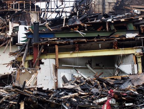 black burned debris and timber and steel beams in a collapsed building destroyed by fire