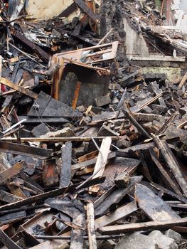 black burned timbers planks and debris in a collapsed house destroyed by fire
