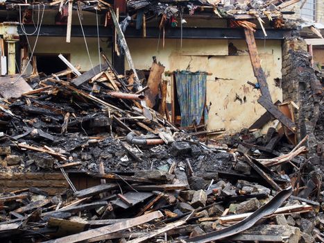 black burned timbers and walls in a collapsed house destroyed by fire