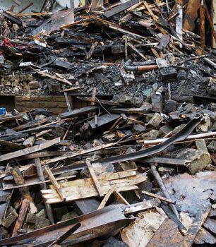 a heap of burned and scattered bricks beams and rubble after a fire in a large building