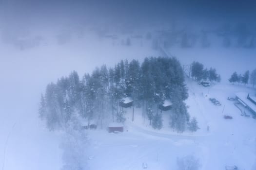 GRANO, SWEDEN FEBRUARY 08, 2020: Aerial view at bird’s nest up high in the tree canopy, houses of Grano Beckasin, tourist place at shores of beautiful Umeriver winter foggy nature, Subarctic Sweden