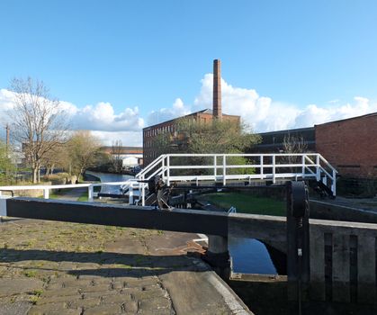 the historic castleton mill near armley in leeds and oddy lock gates and footbridge crossing the canal