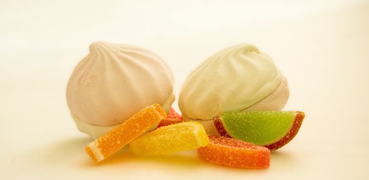 Fruit jelly slices and marshmallows on a white background