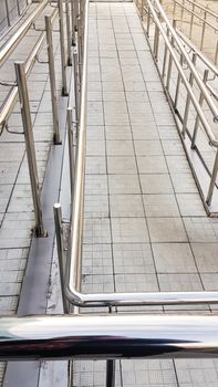 Close-up, entrance to the building with a wheelchair ramp and metal handrails, outdoor, vertical photo.