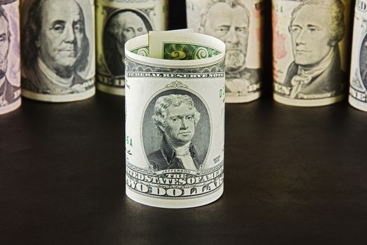 President with bills two dollars on a background of presidents from other denominations

