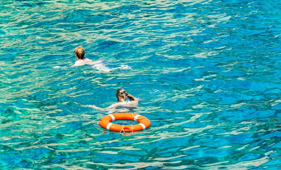 In beryuzovoy water near the lifeline two women float

